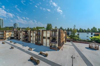A parking lot with several cars and a building in the background.